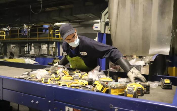 Li-Cycle worker handling battery packs