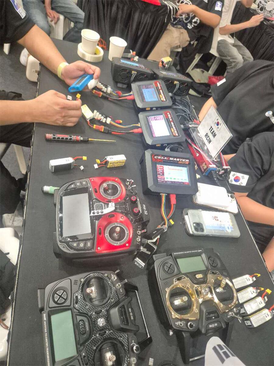 Technicians perform final voltage and temperature checks on LiPo packs before matches.